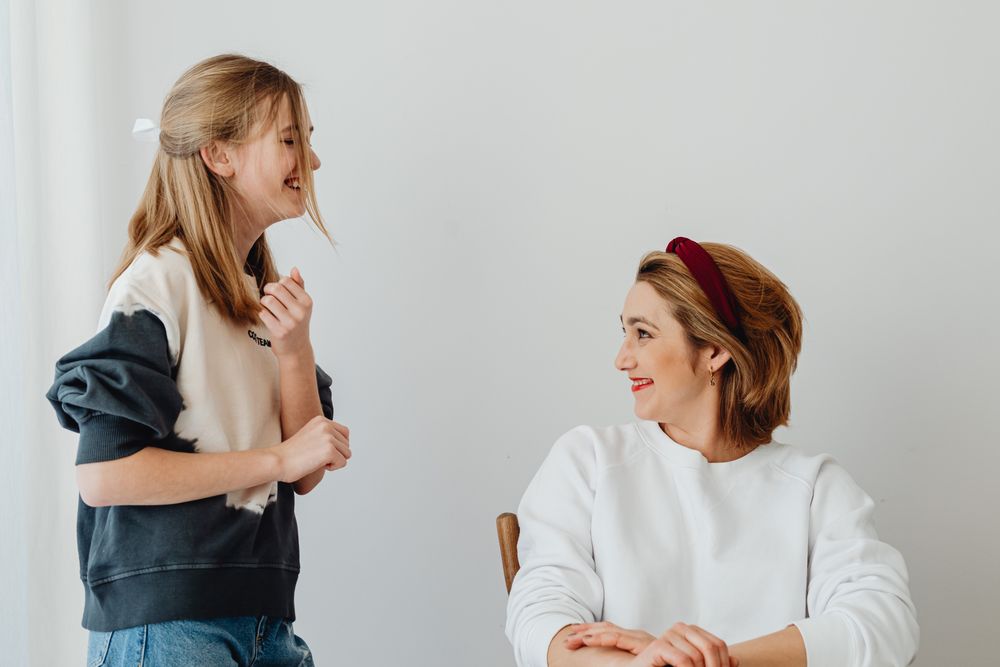 A mother and daughter smiling together at home